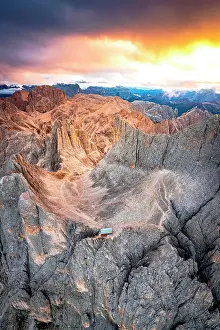 Torri Del Vajolet Prints: Aerial view of Rifugio Passo Santner mountain hut and Torri Del Vajolet under a fiery sky at dawn in autumn