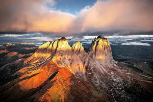 Aerial view of Sassopiatto and Sassolungo under pink clouds in the scenic autumn sky at dawn, Val di Fassa, Dolomites, Italy