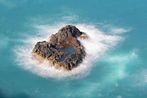 Rock Formations Collection: Aerial view of small rock island amongst waves, Madeira, Portugal