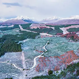 Highland Region Prints: Aerial view over snow covered forests in Glen Garry next to Loch Garry