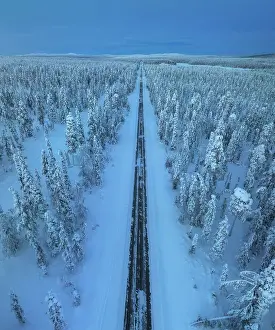 Loneliness Prints: Aerial view of straight road during a winter evening in the Yllas-Pallastunturi National Park