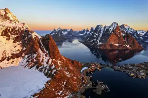 Reine Prints: Aerial view at sunset over the rugged snowy peaks and the bay of Reine in winter