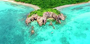 West Indies Prints: Aerial view of a tourist on a boat moored in the blue lagoon surrounding the green headland of Pearns Point