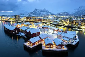 Finish Prints: Aerial view of traditional houses covered with snow in the illuminated village of Svolvaer at night