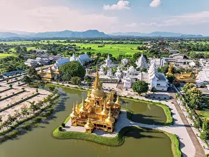 Chiang Rai Prints: Aerial view of Wat Rong Khun also know as White Temple and golden stupa overlooking a lake
