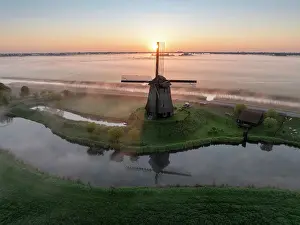 Moody Light Prints: An aerial view of a windmill in the mist at dawn, North Holland, Netherlands