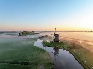 Moody Light Prints: An aerial view of a windmill in the mist at dawn, North Holland, Netherlands