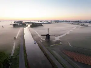 Moody Light Prints: An aerial view of a windmill in the mist at dawn, North Holland, Netherlands