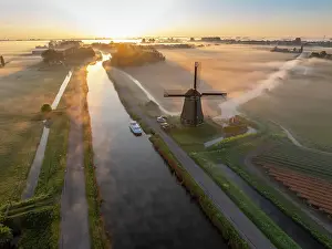 Moody Light Prints: An aerial view of a windmill in the mist at dawn, North Holland, Netherlands