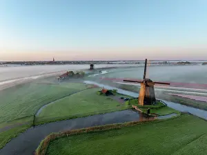 Schermerhorn Prints: An aerial view of windmills & Schermerhorn in the mist at dawn, North Holland, Netherlands