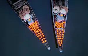 Straight Down Prints: Aerial view of women laying floating lanterns on the Perfume River at dusk
