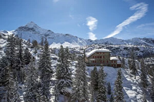 Aerial view of the Zoia Hut in winter with Scalino Peak in the background. Valmalenco