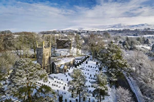 Aerial vista of St Petrocs Church and Lydford Castle on a snowy winter morning in