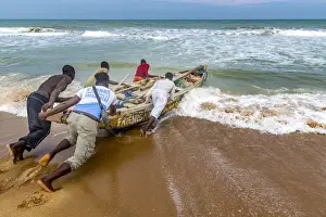 Benin Prints: Africa, Benin, Grand Popo. A group of fishermen taking their boat into the water