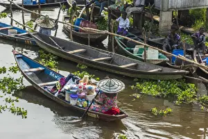 Channels Prints: Africa, Benin, Lake Nokoua. A woman drives her canoe to the market in the famous