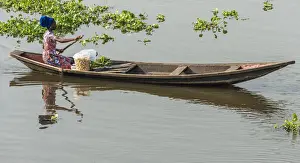 Africa, Benin, Lake Nokoua. A woman on the way to the market in the famous stilt
