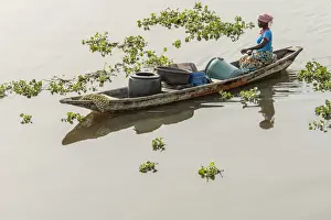 Africa, Benin, Lake Nokoua. A woman on the way to the waterseller in the famous stilt