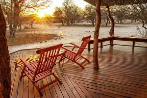 Deck Prints: Africa, Botswana, Kalahari, Deception Valley lodge. the deck of one chalet at sunrise