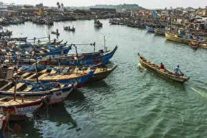 Africa, Ghana, Elmina harbour. Fishermen with their boats returning to the market