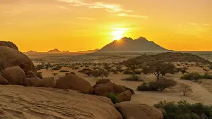 Gravel Road Prints: Africa, Namibia. Sunset behind a mountain near Spitzkoppe area