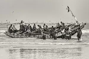 Africa, Senegal, Kayar. Fishermen with their boat going out