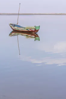 Africa, Senegal, Sine-Saloum-Delta. Fishing boat reflecting in the water