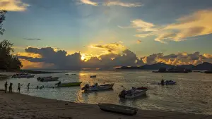 Africa, Seychelles, La Digue. Kids playing at sunset in the little Harbour of La Digue