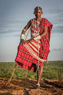 Images Dated 19th December 2022: Africa, Tanzania, Manyara Region. Maasai man on a rock overlooking the landscape towards the plain
