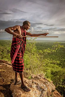 Africa, Tanzania, Manyara Region. Msai man on a rock overlooking the landscape towards the plain of Tarangire National park