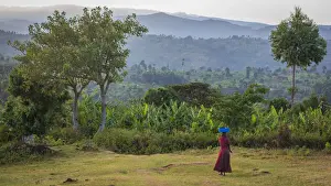Africa, Uganda, Sipi Falls. Woman walking through the rural landscape