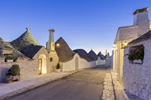 Alley Prints: Alley between white trulli houses at dusk. Unesco World Heritage Site, Alberobello