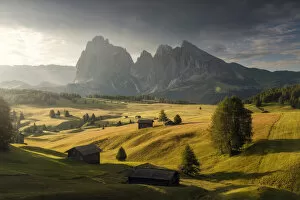 Alpine meadow and wooden huts in the Dolomites, Italy