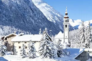 Alpine village of Bever and old church after a snow blizzard in winter, Engadine