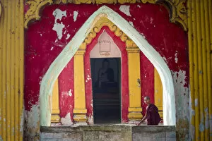 Images Dated 1st March 2016: Amarapura, Mandalay region, Myanmar. Monk through the window of a colorful pagoda