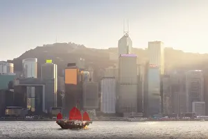 Tsim Sha Tsui Prints: Ancient Dunkling boat sails in front of cityscape of Hong Kong during sunset
