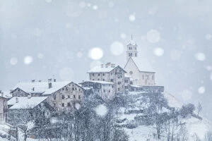 Snowfall Collection: the ancient village of Colle Santa Lucia with the church on the hill under a snowfall