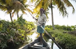 Lens Flare Prints: Anthony the boatman guiding the vessel through Keralan backwaters near North Paravoor
