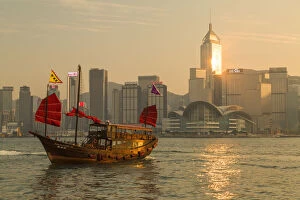 Orient Gallery: Aqua Luna junk boat and Hong Kong Island skyline at sunset, Hong Kong, China