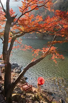 Traditional Dress Gallery: Arashiyama, Kyoto, Kyoto prefecture, Kansai region, Japan. Woman with red umbrella