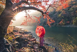Arashiyama, Kyoto, Kyoto prefecture, Kansai region, Japan. Woman with red umbrella