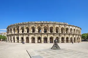 Nimes Prints: Arenas of Nimes, Roman amphitheater with bullfighter statue, Nimes, Gard