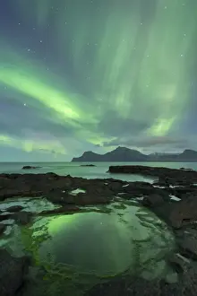 Aurora Borealis above the island of Kalsoy, photographed from the coastline of Gjogv