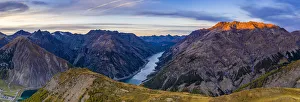 Mountain Ridge Prints: Autumnal sunset over Pizzo del Ferro peak and lake of Livigno, aerial view