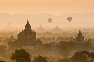 Bagan, Mandalay region, Myanmar (Burma). Pagodas and temples with balloons at sunrise