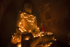 Bagan, Mandalay region, Myanmar (Burma). Young monk praying at a giant brick-make