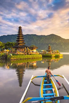 Bali, Indonesia, South East Asia. Balinese man with traditional clothes paddling an