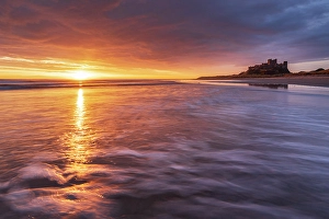 Northumberland Prints: Bamburgh Castle at sunrise on the coast of Northumberland, England