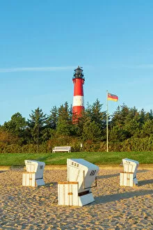 Images Dated 12th January 2023: Beach chairs near German flag and Hornum lighthouse in background at sunrise, Hornum beach, Sylt