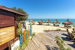 Beach Chairs Prints: Beachfront huts, colorful fence, relaxing scene. Madagascar, Africa. Anakao