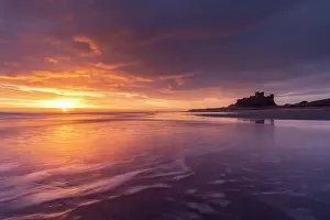 Beautiful sunrise above Bamburgh Castle on the Northumberland coast, England. Spring (March) 2023